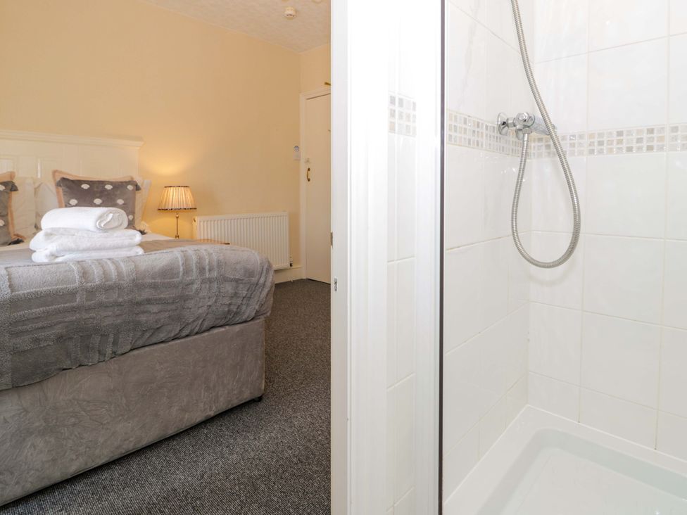 A bedroom with a bed and a shower at The Causeway in Llandudno