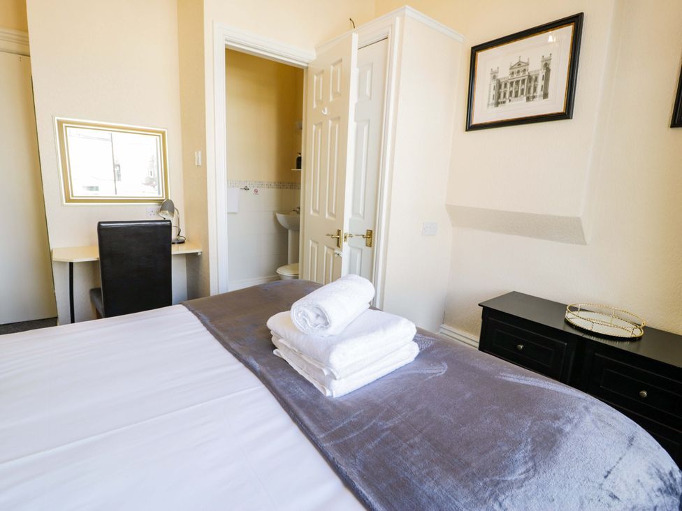 A bedroom with a bed and desk at The Causeway in Llandudno