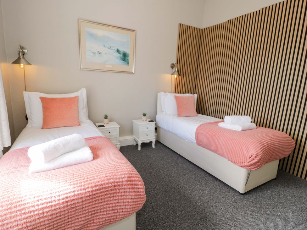 A bedroom with two beds and bedside tables at The Causeway in Llandudno