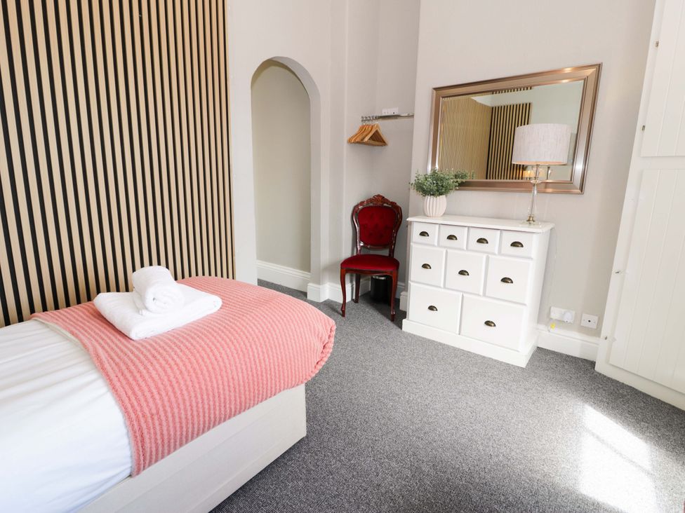 A bedroom with a bed and a dresser at The Causeway in Llandudno