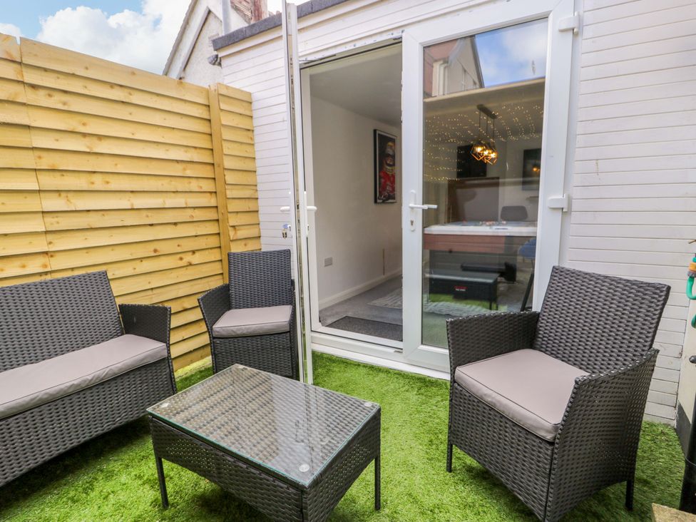 An outdoor seating area with furniture set and door at The Causeway in Llandudno