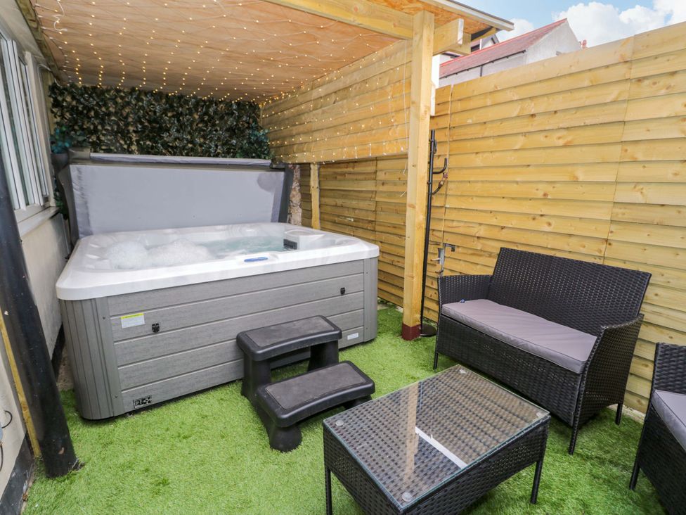 An outdoor area with a hot tub and seating at The Causeway in Llandudno
