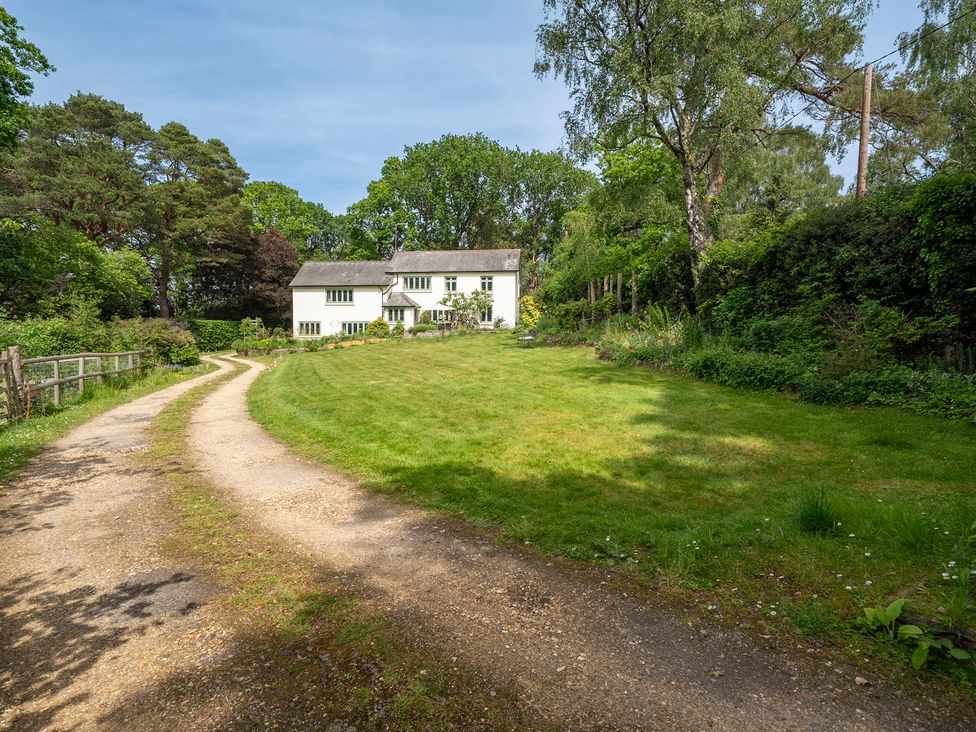 A house with a driveway and grass area at Primrose Spinney in Highwood near Ringwood