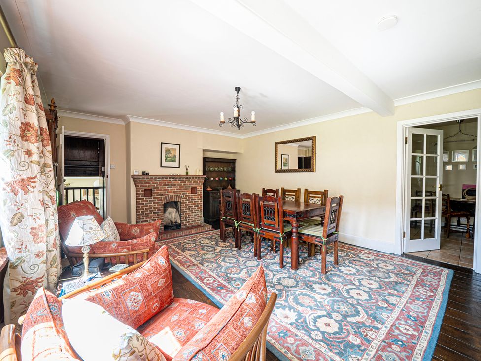 A living room with a dining table and fireplace at Primrose Spinney Highwood near Ringwood