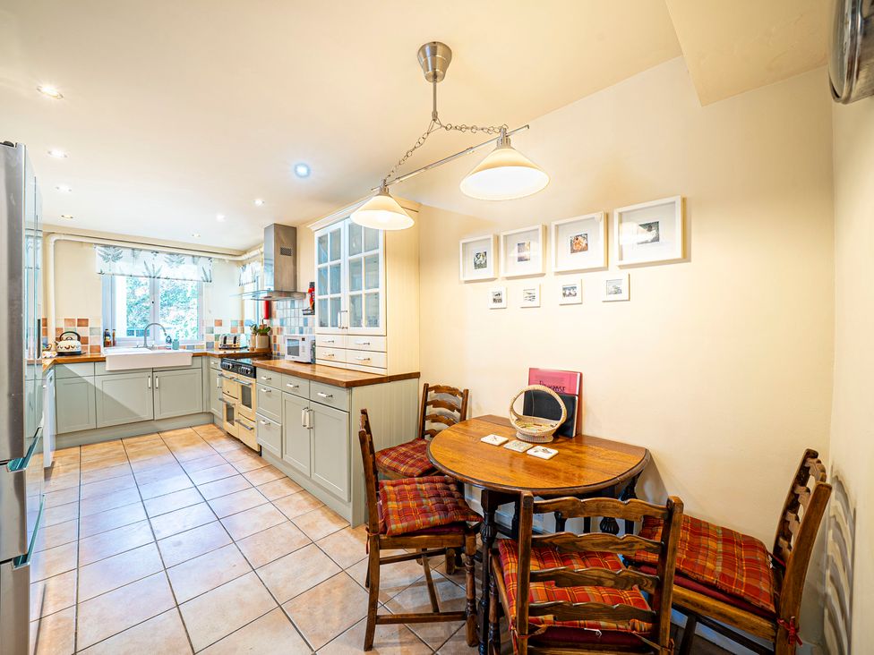 A kitchen with a dining table and chairs at Primrose Spinney in Highwood near Ringwood