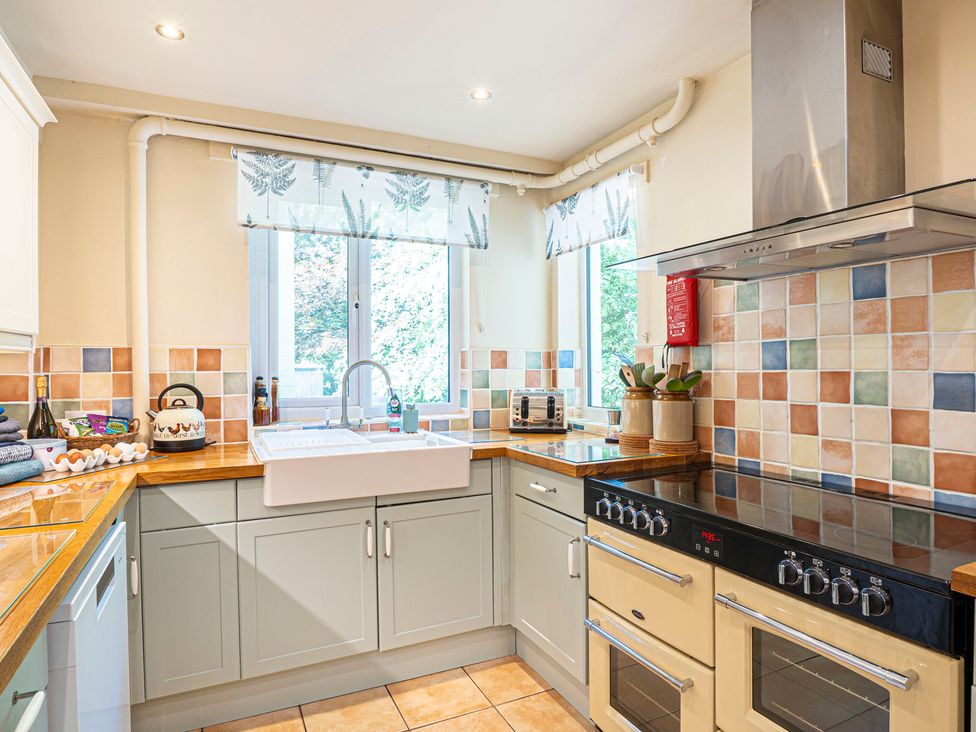 A kitchen with a sink, oven, and wooden countertop at Primrose Spinney, Highwood near Ringwood