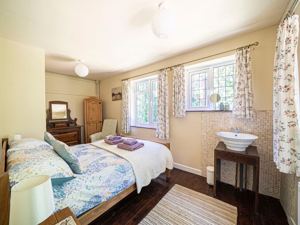 A bedroom with two beds and a washbasin at Primrose Spinney Highwood near Ringwood