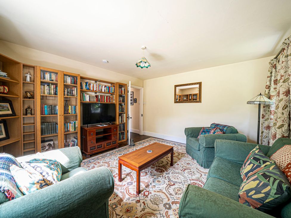 A living room with a television and bookshelf at Primrose Spinney Highwood near Ringwood