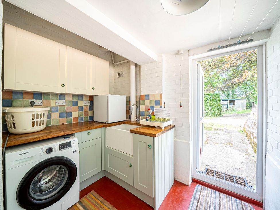 A laundry room with a washing machine and sink at Primrose Spinney Highwood near Ringwood