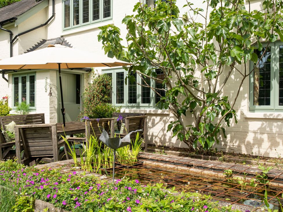 A garden with seating area and water feature at Primrose Spinney Highwood near Ringwood