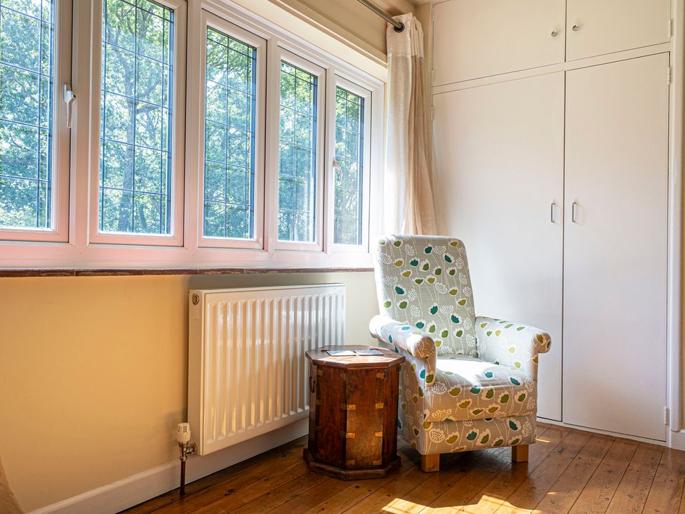 A living room with a chair and side table at Primrose Spinney near Ringwood