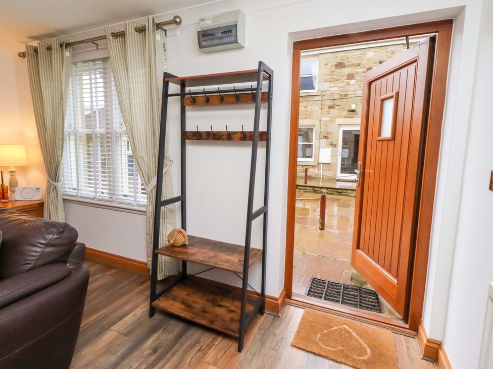 A hallway with a shelf and an open door at 1 Pear Tree Beadnell