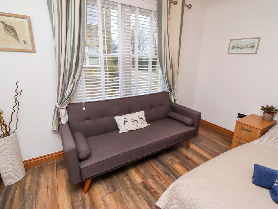 A living room with a sofa and window at 1 Pear Tree in Beadnell