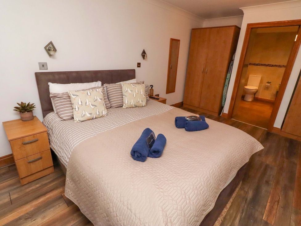 A bedroom with a bed and wardrobe at 1 Pear Tree Beadnell