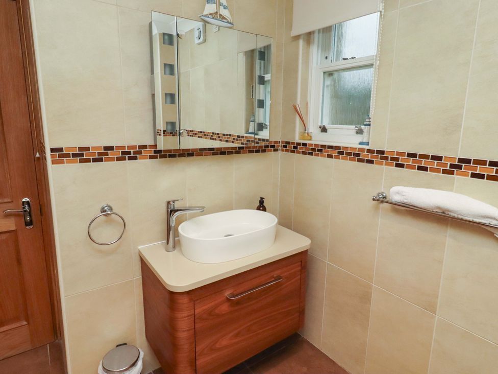 A bathroom with sink and mirror at 1 Pear Tree in Beadnell