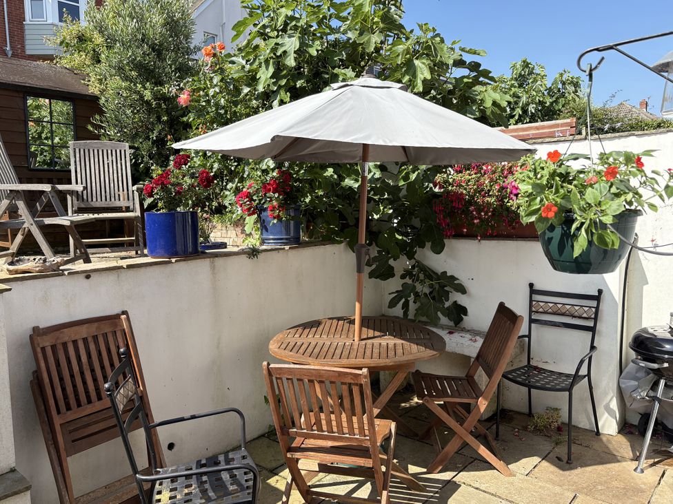 An outdoor seating area with a table and chairs at Quarrier's Rest in Swanage