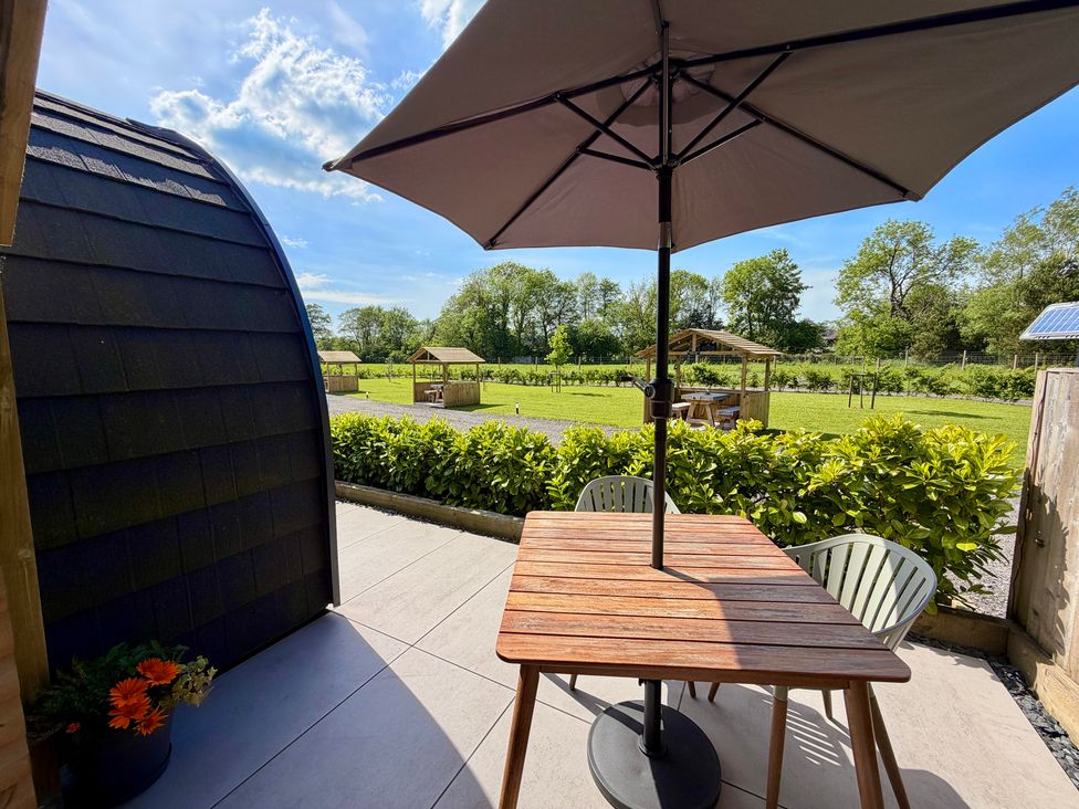 An outdoor seating area with a table and umbrella at Oh Deer in Ashbourne