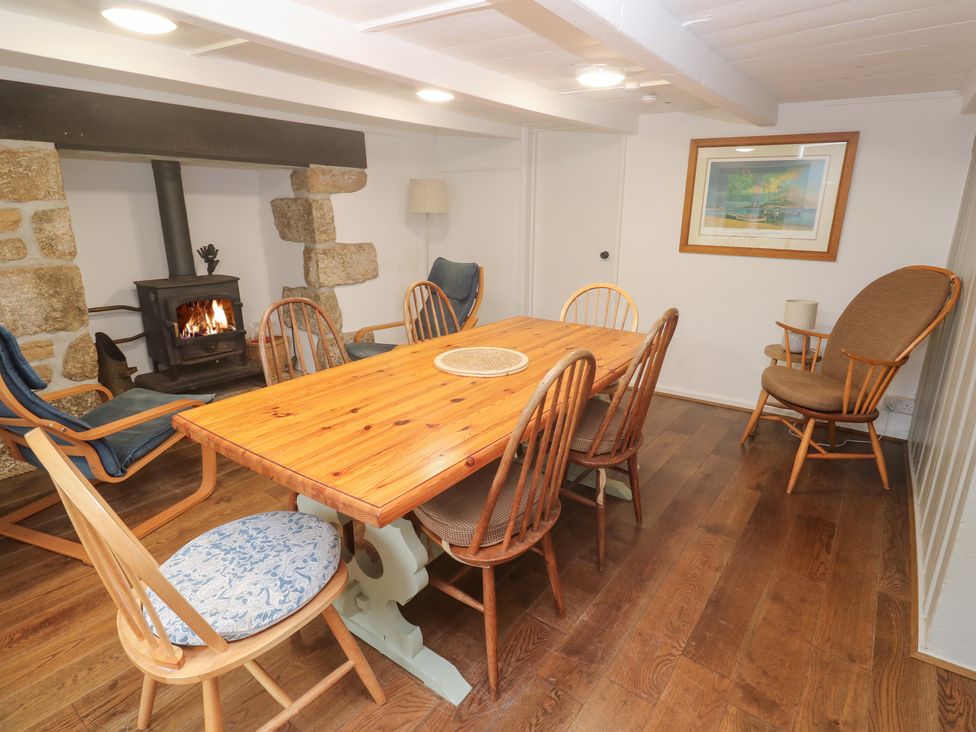 A dining room with a wooden table and chairs at Sunnyvale Cottage in Rosudgeon