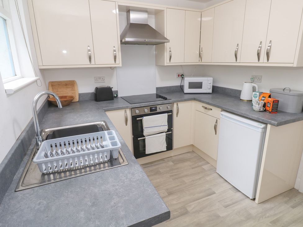 A kitchen with a sink and appliances at Sunnyvale Cottage in Rosudgeon