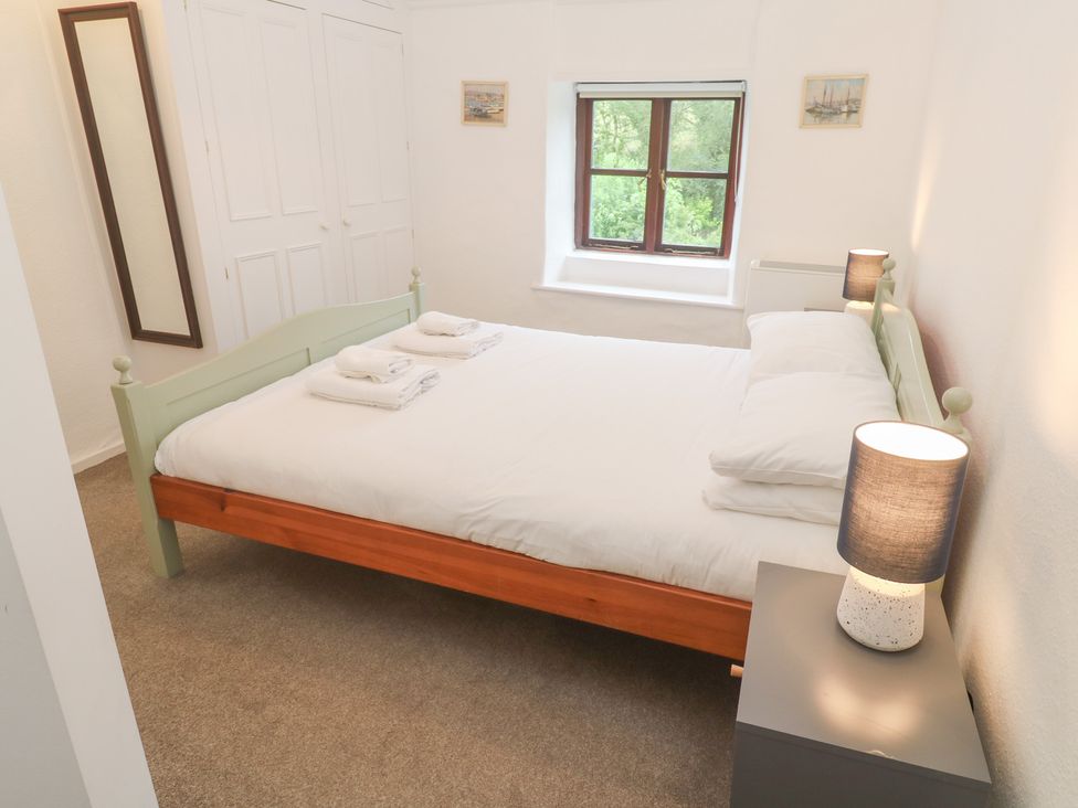 A bedroom with a bed and nightstand at Sunnyvale Cottage in Rosudgeon