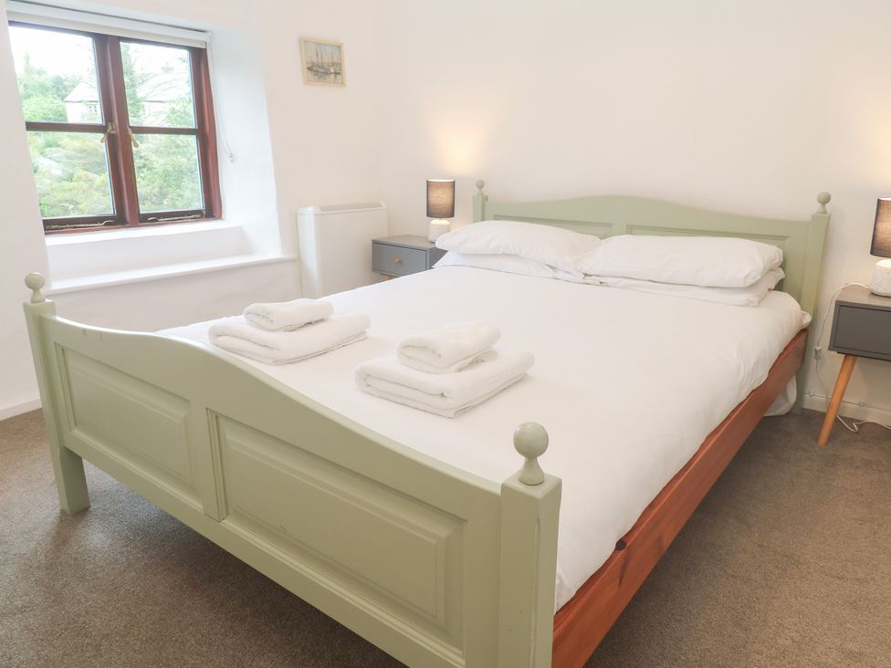 A bedroom with a bed and towels at Sunnyvale Cottage in Rosudgeon
