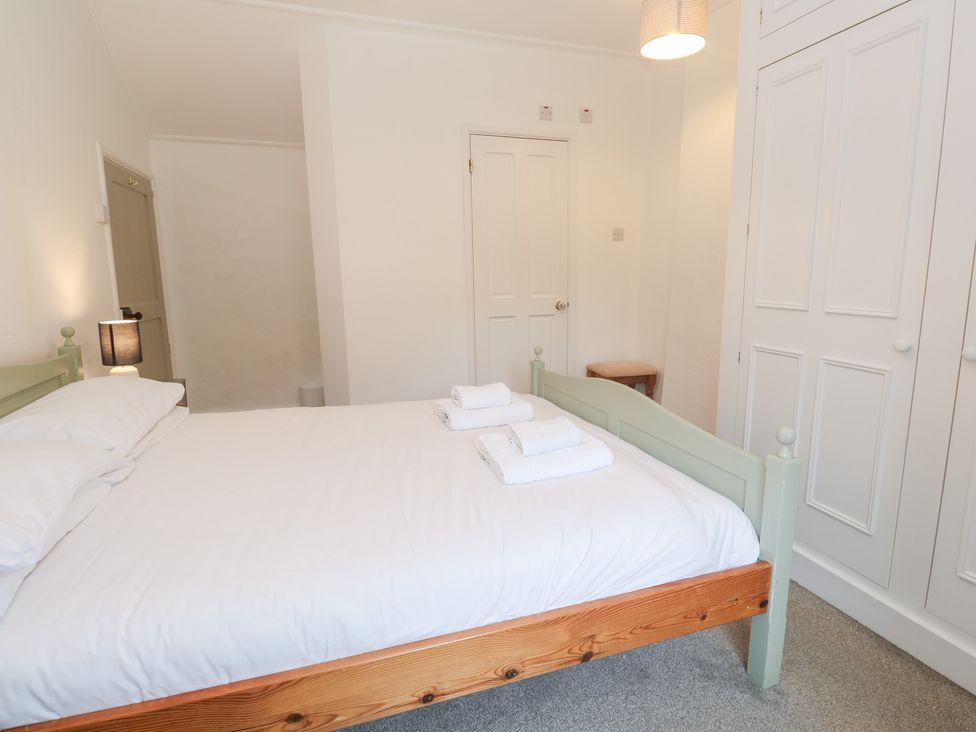 A bedroom with a bed and wardrobe at Sunnyvale Cottage in Rosudgeon