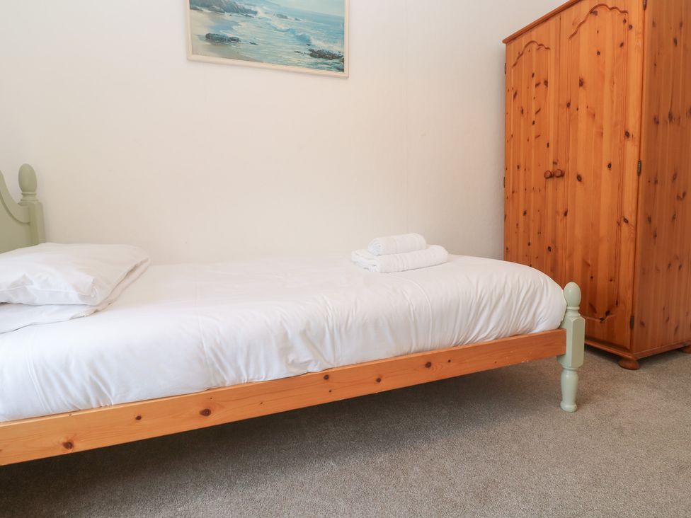 A bedroom with a bed and wardrobe at Sunnyvale Cottage Rosudgeon