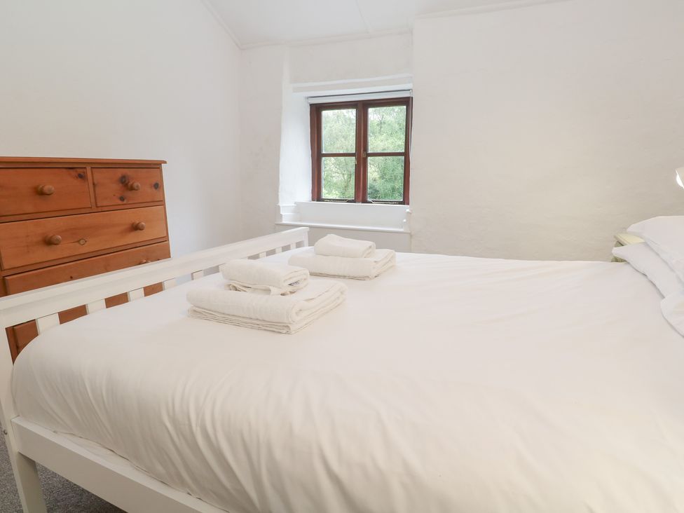 A bedroom with a bed and dresser at Sunnyvale Cottage in Rosudgeon
