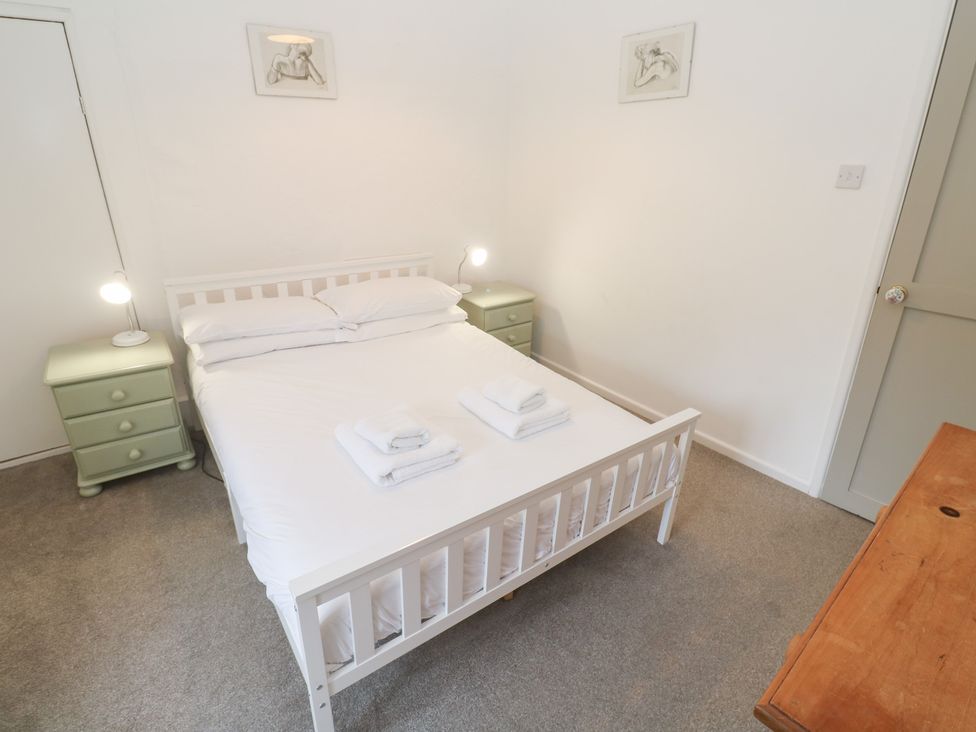 A bedroom with a bed and bedside tables at Sunnyvale Cottage in Rosudgeon