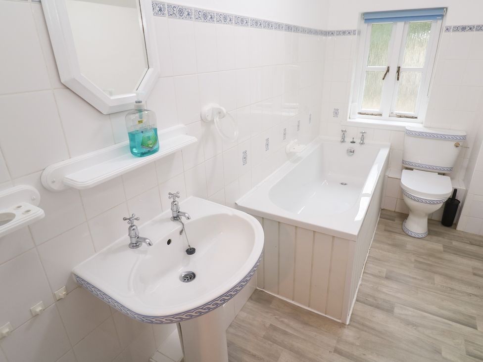 A bathroom with a sink, tub, and toilet at Sunnyvale Cottage in Rosudgeon