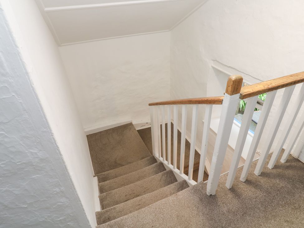 A staircase with carpet and a handrail at Sunnyvale Cottage Rosudgeon
