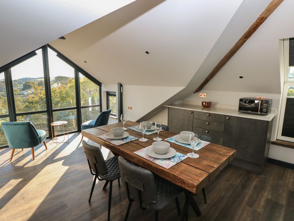 A kitchen with dining table and chairs at 11 Brython Place in Tenby