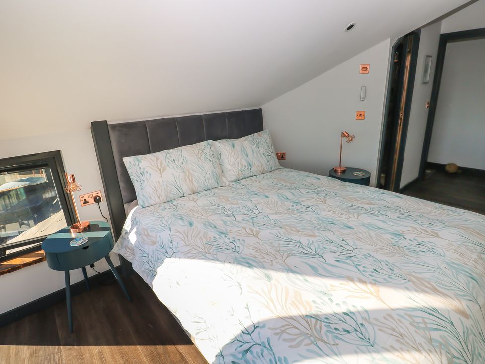 A bedroom with a bed and bedside table at 11 Brython Place Tenby