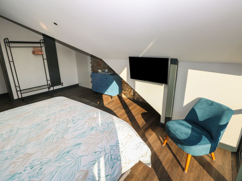 A bedroom with a bed and a television at 11 Brython Place Tenby
