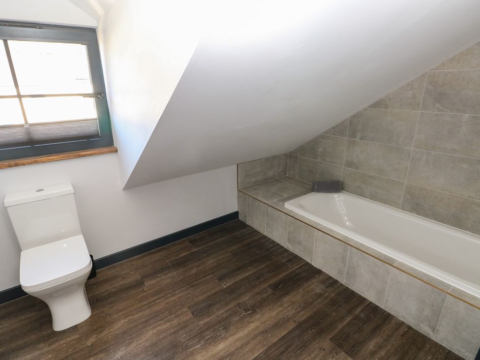 A bathroom with a toilet and bathtub at 11 Brython Place in Tenby