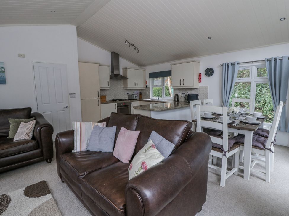 A living room with a sofa and dining area at Seacroft in Stepaside near Kilgetty