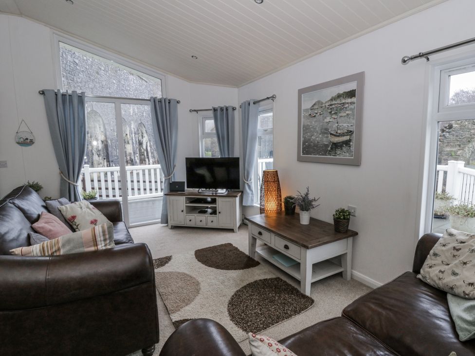 A living room with a television and sofa at Seacroft Stepaside near Kilgetty