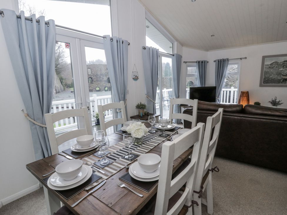 A dining room with a table set for meals at Seacroft near Kilgetty