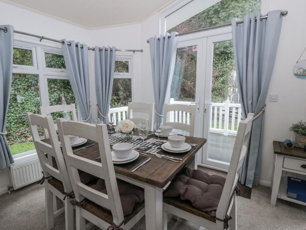 A dining room with a table and chairs at Seacroft in Stepaside near Kilgetty
