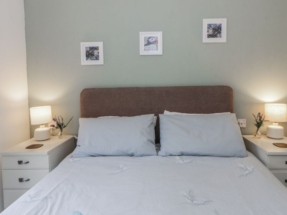 A bedroom with a bed and bedside tables at Seacroft in Stepaside near Kilgetty