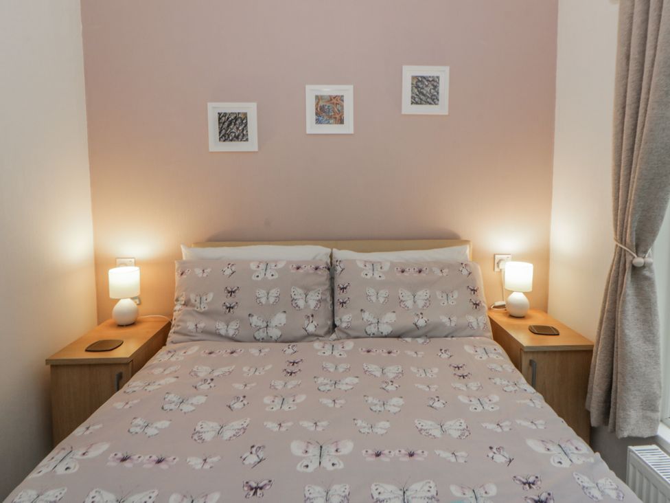 A bedroom with a bed and bedside tables at Seacroft in Stepaside near Kilgetty