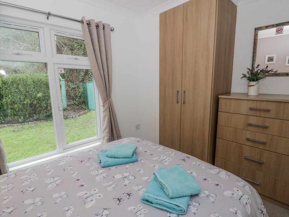 A bedroom with two towels on the bed at Seacroft Stepaside near Kilgetty