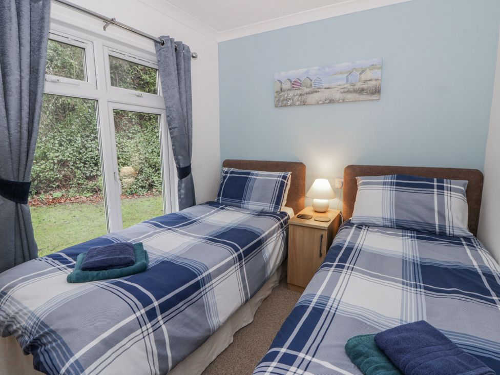 A bedroom with two single beds and a nightstand at Seacroft near Kilgetty