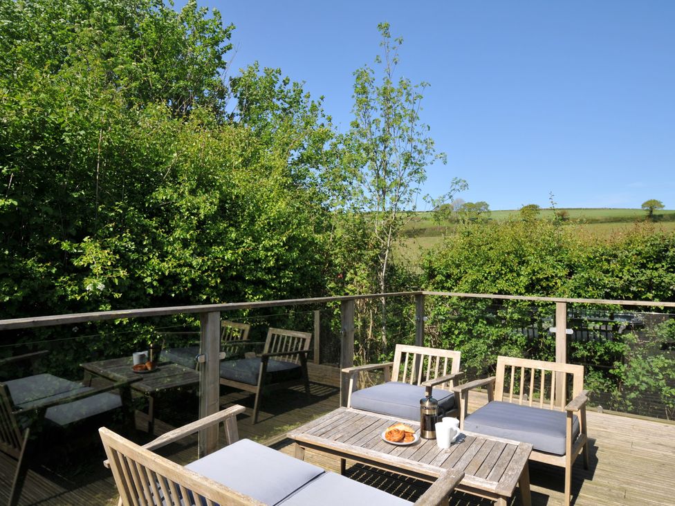 An outdoor seating area with a table and chairs at 7 Valley View in Lanreath