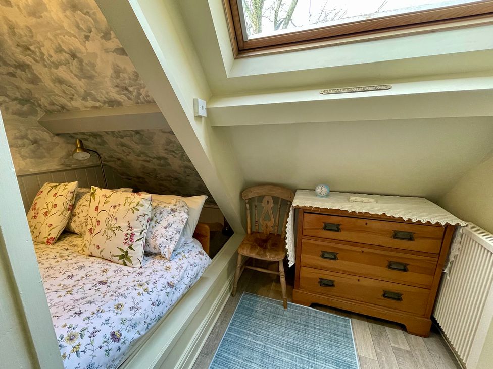A bedroom with a bed and dresser at The Ticket Office in Ruswarp near Whitby