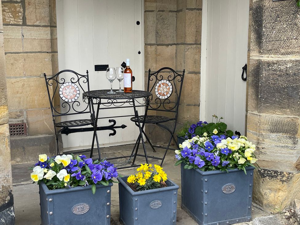 A table with chairs and flower pots at The Ticket Office in Ruswarp near Whitby