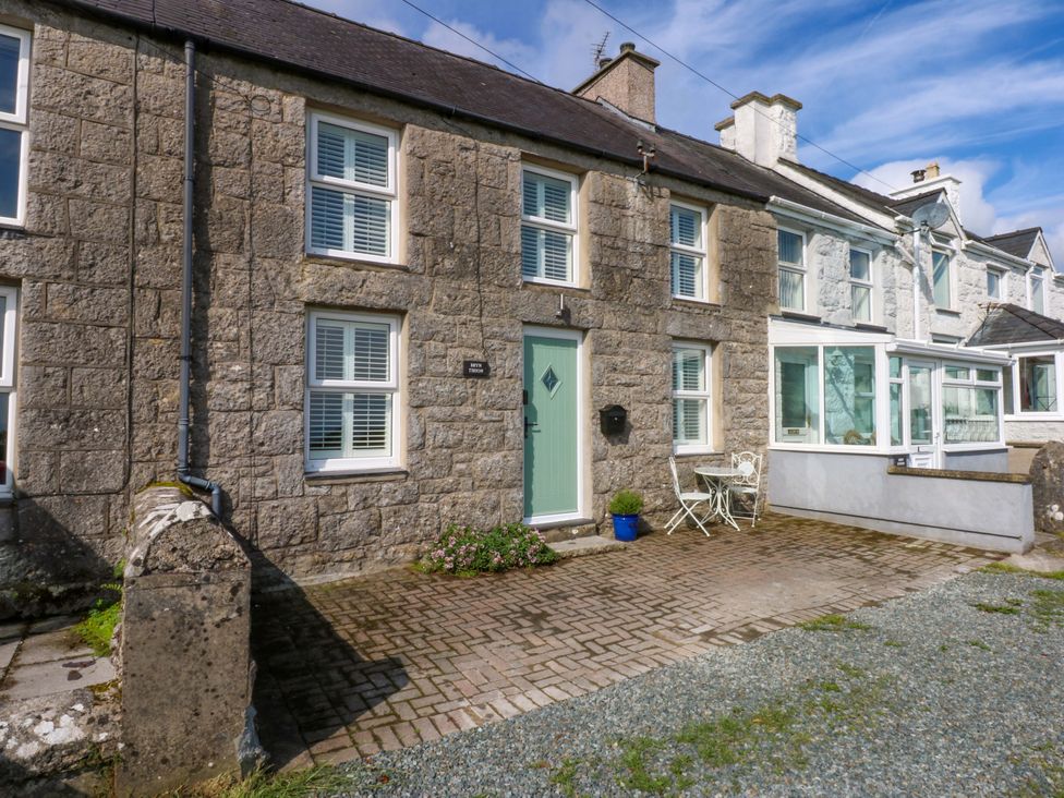 A house with a green door and pathway at Bryn Tirion in Moelfre