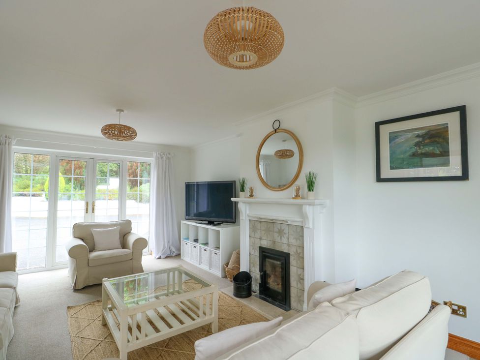 A living room with a fireplace and television at Bwthyn Clai in Llangefni