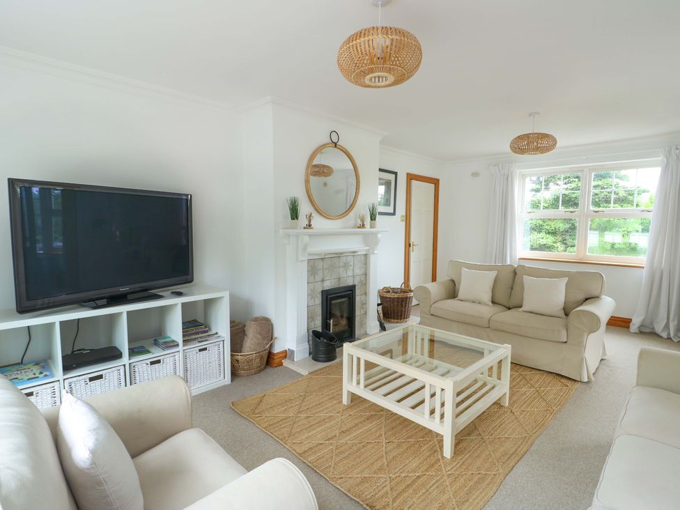 A living room with a television and sofa at Bwthyn Clai in Llangefni