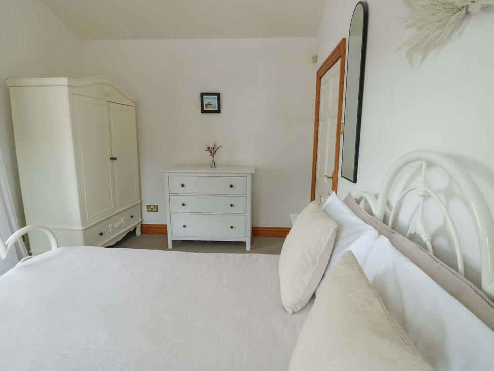 A bedroom with a bed and furniture at Bwthyn Clai in Llangefni